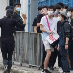 香港中学文凭试开考 周润发跑步路过向考生挥手打气